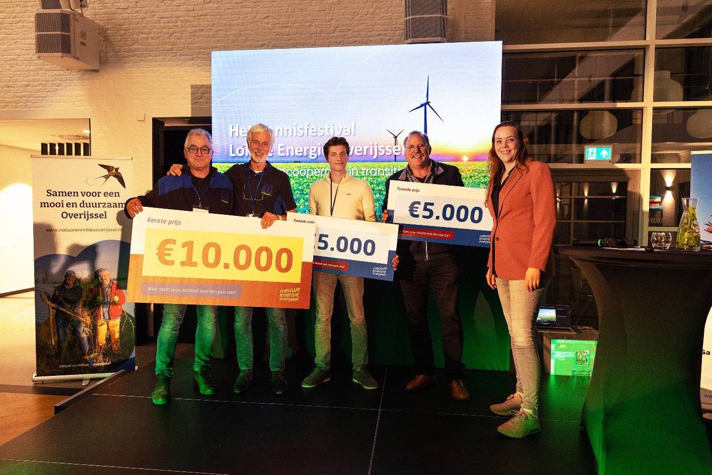 Groep mensen ontvangt cheques tijdens een energieprijsuitreiking.