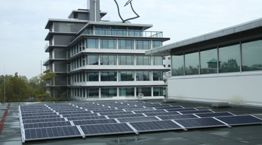 Provinciehuis Overijssel - Zonnepanelen op een plat dak met daarachter een modern kantoorgebouw met veel glas.