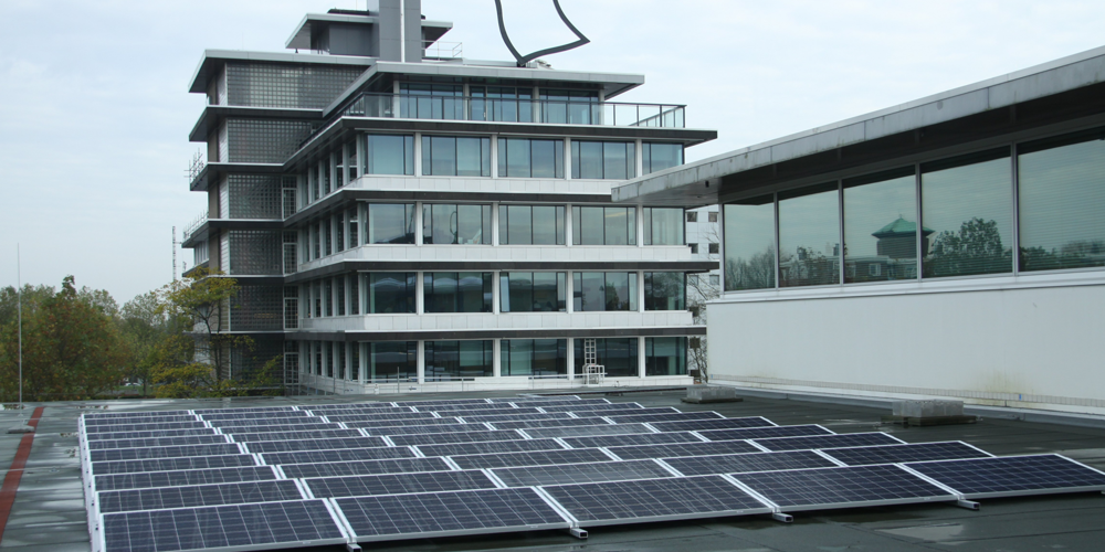 Provinciehuis Overijssel - Zonnepanelen op een plat dak met daarachter een modern kantoorgebouw met veel glas.