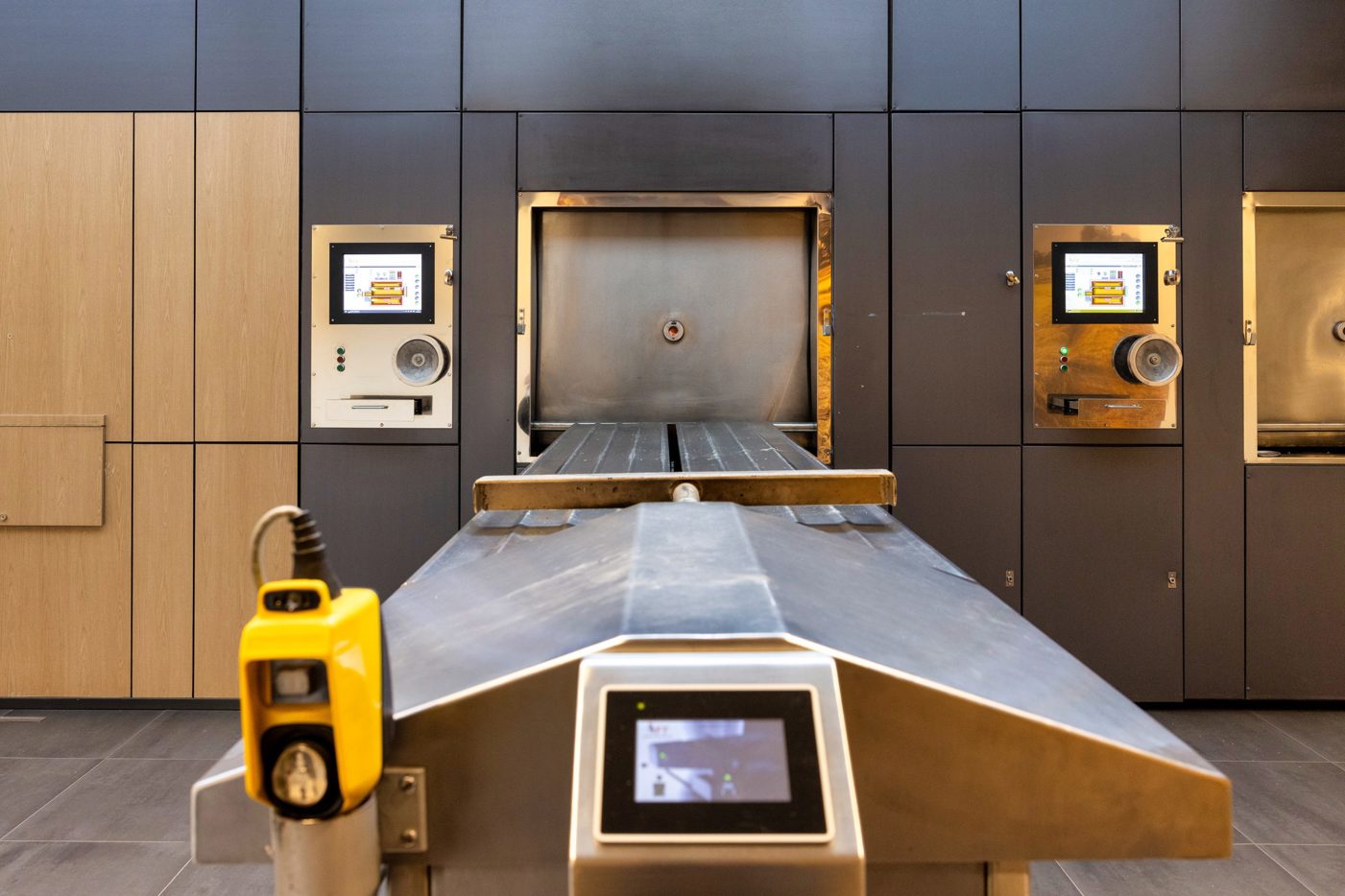 Vooraanzicht van een bestaande crematieoven bij de Crematoria Twente, die niet in gebruik is. Met links op de muur het bedieningspaneel en rechts een stukje van een andere crematieoven.